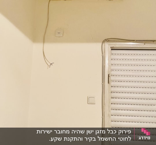 מזגן מותקן על קיר עם חוטי חשמל חשופים